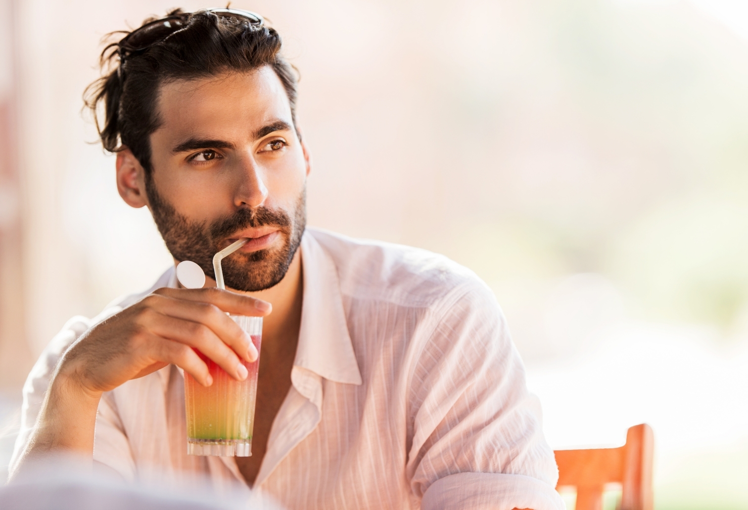 man in sun drinking and wearing breathable fabric shirt